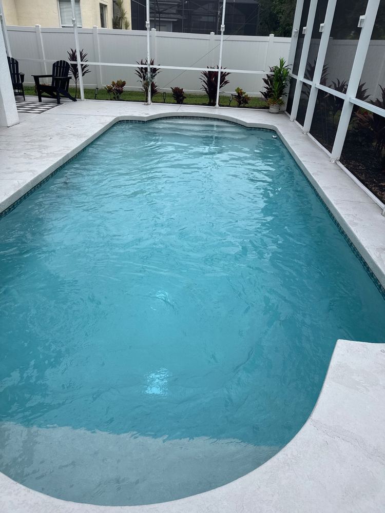 Rectangular pool with clean light-blue water in a screened lanai